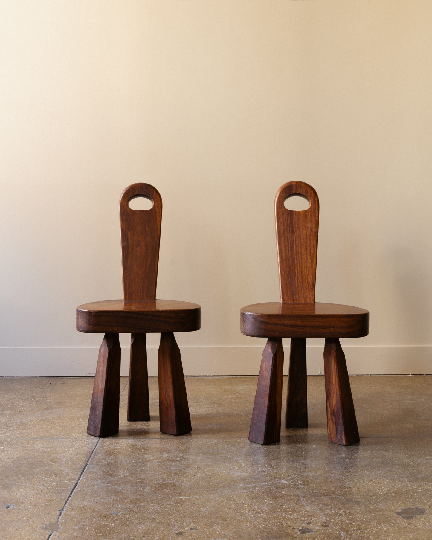 Image of French Brutalist tripod chairs showing faceted tripod legs and tall carved backrests, France 1960s.