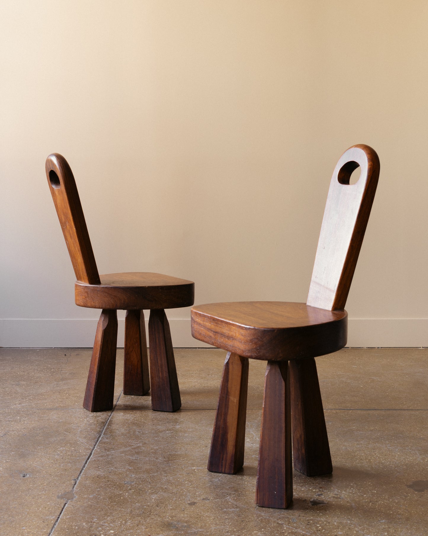 Image of French Brutalist tripod chairs showing faceted tripod legs and tall carved backrests, France 1960s.