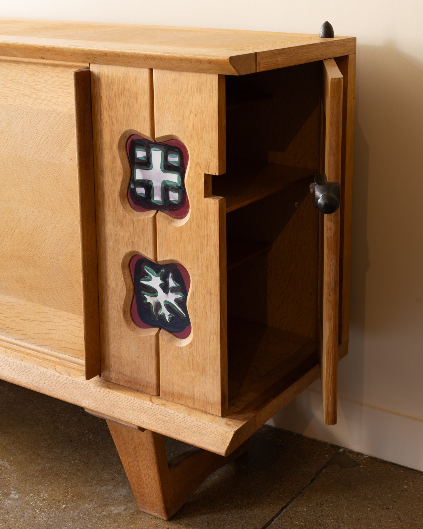 Oak buffet by Guillerme & Chambron showing right-side Danikowski ceramic panel and left-side sliding oak doors; France, 1960s.