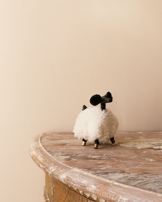 Handmade sheep figure by Alicia Sciberras with timber body, sherpa coat, and brass and leather details.